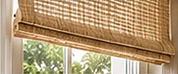 Natural woven roman shade over a window, custom window treatments by PaperWorks Plus